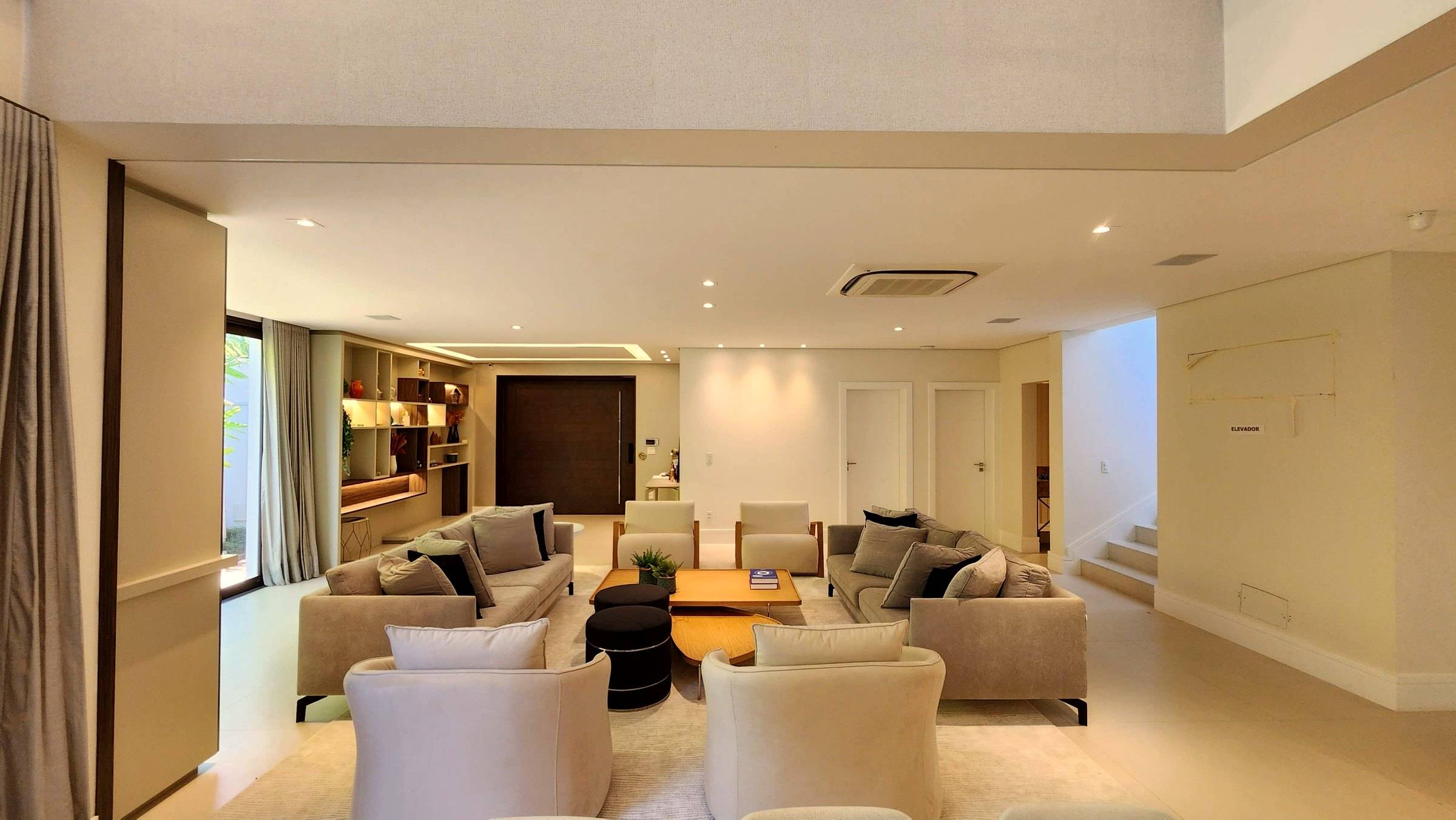 Vista ampla do living integrado, com dois conjuntos de estar
