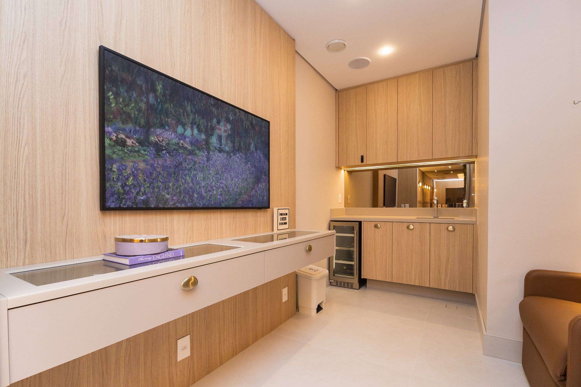 Sala de procedimentos com painel de carvalho, bancada clara e quadro com paisagem